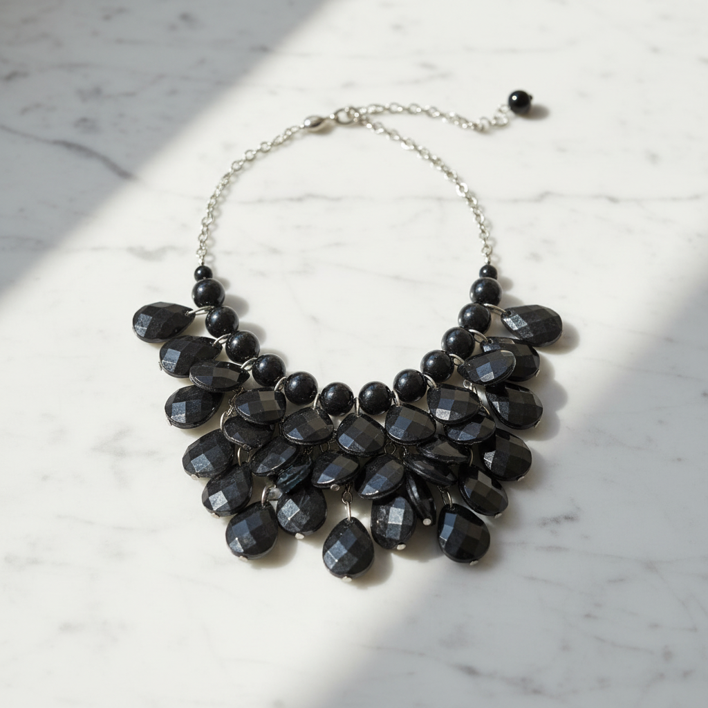 Black beaded necklace on a marble surface