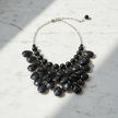 Black beaded necklace on a marble surface