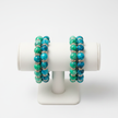 Two turquoise and green marbled beaded bracelets on a jewellery display stand