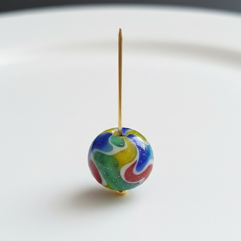 Gold headpin threaded through a colourful glass bead showing how to use headpins in jewellery making