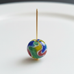 Gold headpin threaded through a colourful glass bead showing how to use headpins in jewellery making