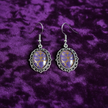 Gothic purple glass earrings flat lay on dark velvet