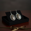 Large black and gold oval drop earrings gift presentation on velvet tray