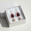 Burgundy crystal teardrop earrings presented in a white gift box with tissue paper