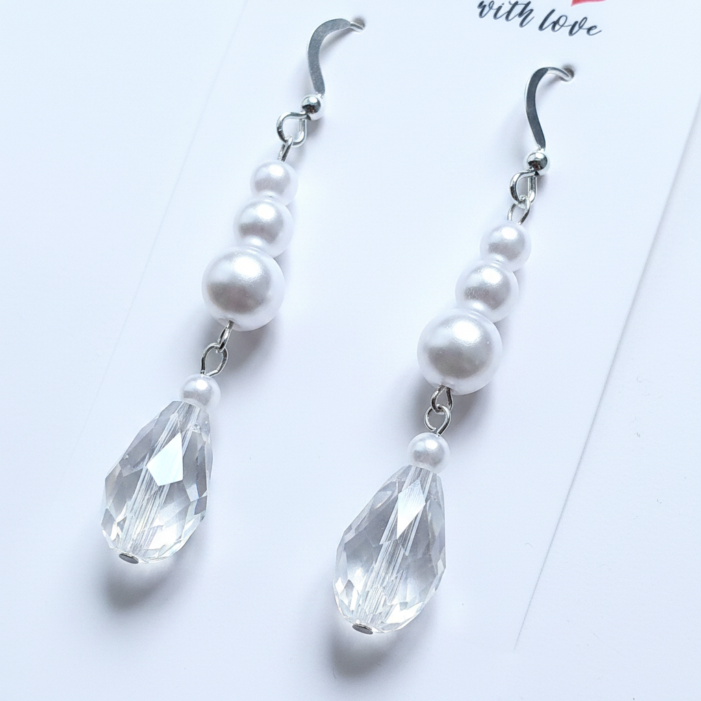 Close-up detail of sterling silver pearl and crystal teardrop earrings