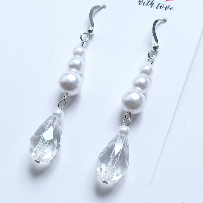Close-up detail of sterling silver pearl and crystal teardrop earrings