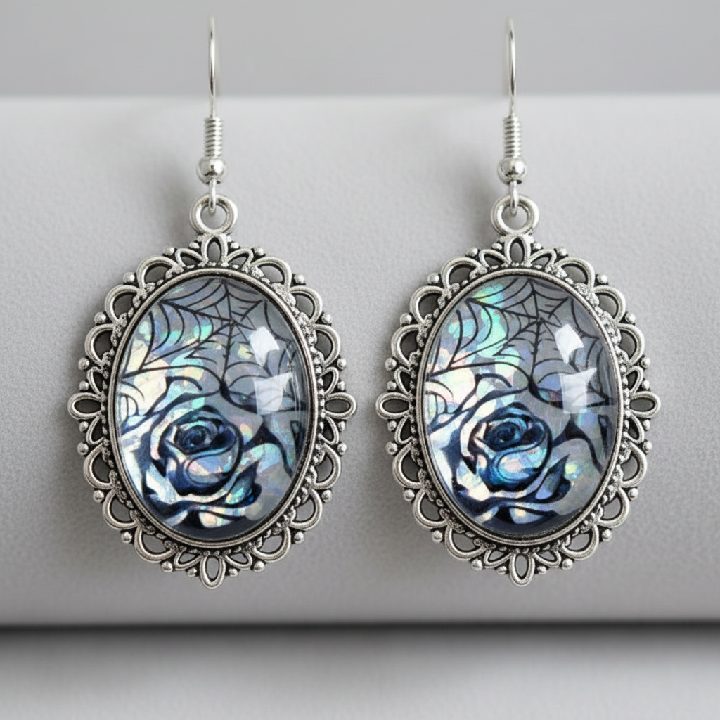 Close-up of antique silver filigree oval earrings showing iridescent rose and spiderweb cabochon shimmer
