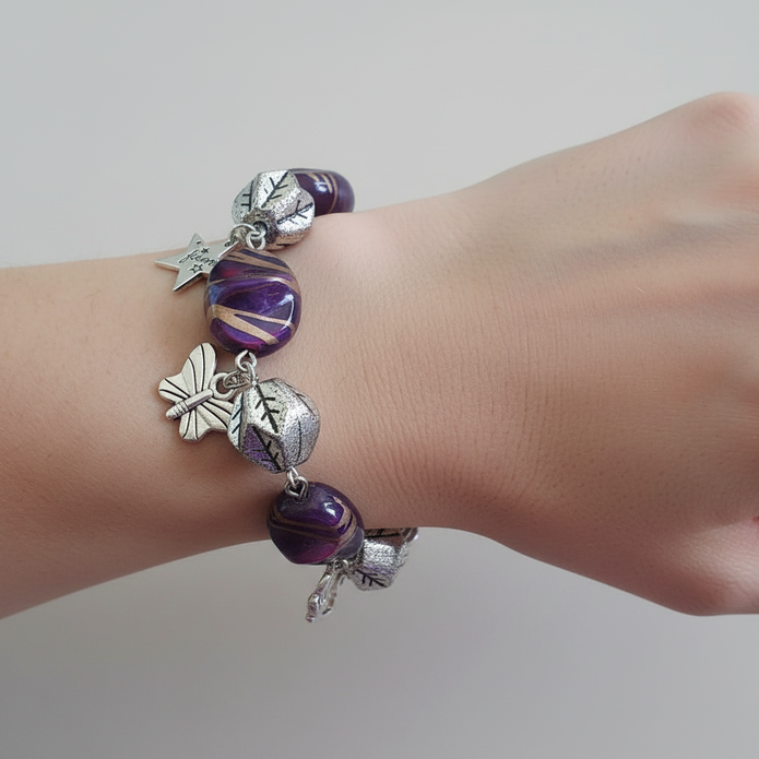 Rescued and remade plum charm bracelet with Aries zodiac charm worn on a model's wrist