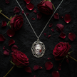 Gothic skull and rose cameo pendant necklace flat lay on black lace with red roses, dark gothic styling