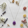 Rescued and remade purple marbled pendant necklace flat lay with dried flowers