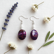 Rescued plum drop earrings flat lay with dried flowers