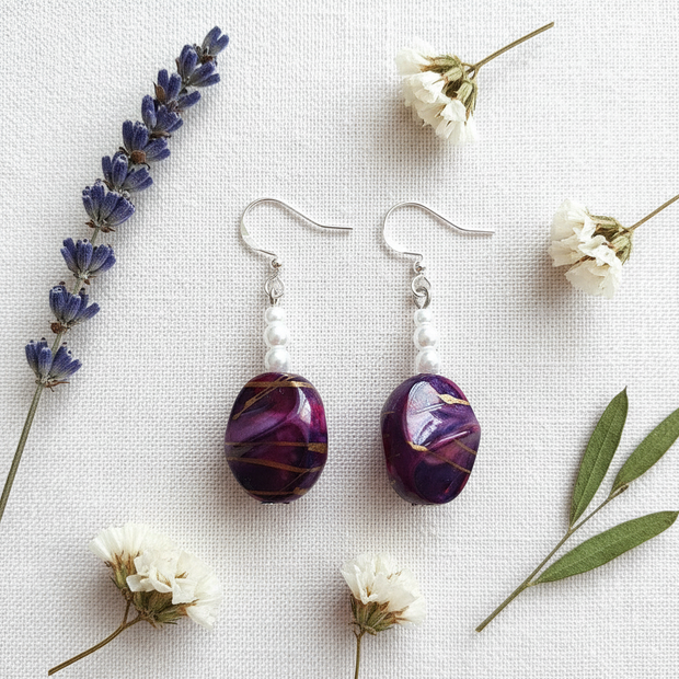 Rescued plum drop earrings flat lay with dried flowers