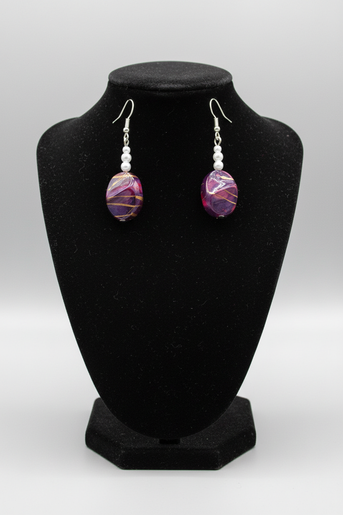 Rescued plum drop earrings displayed on earring stand
