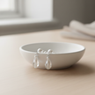Sterling silver pearl and crystal teardrop earrings on white ceramic jewellery stand