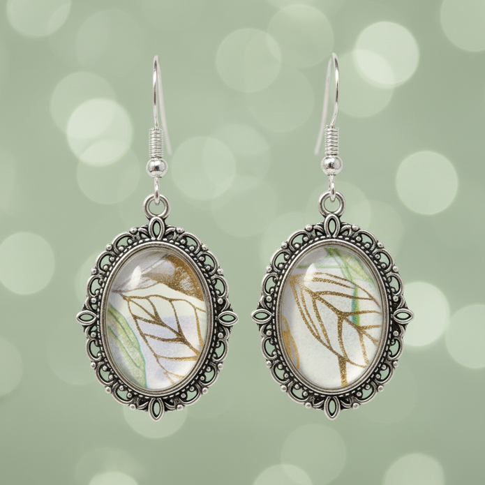 Close-up detail of botanical leaf cabochon drop earrings showing silver filigree metalwork