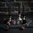 Gothic purple glass earrings styled with candles and dried flowers