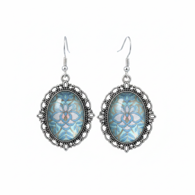Iridescent blue holographic cabochon drop earrings on white background studio shot