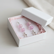 Pink bead and star charm earrings presented in a white gift box with pink tissue paper