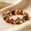 Copper pearl and gold mixed bead stretch bracelet styled on cream fabric