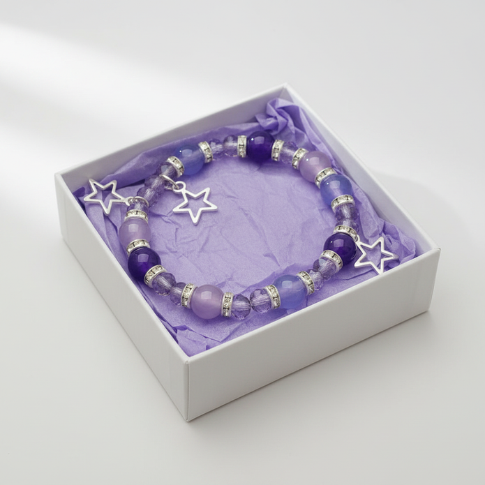 Purple and lilac star charm bracelet in a white gift box with purple tissue paper