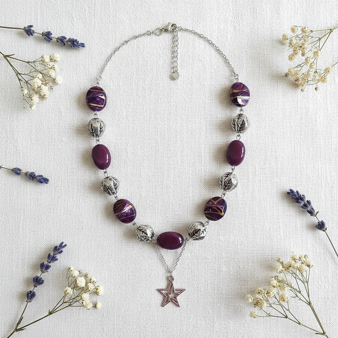 Rescued plum bead necklace with star pendant flat lay with dried flowers