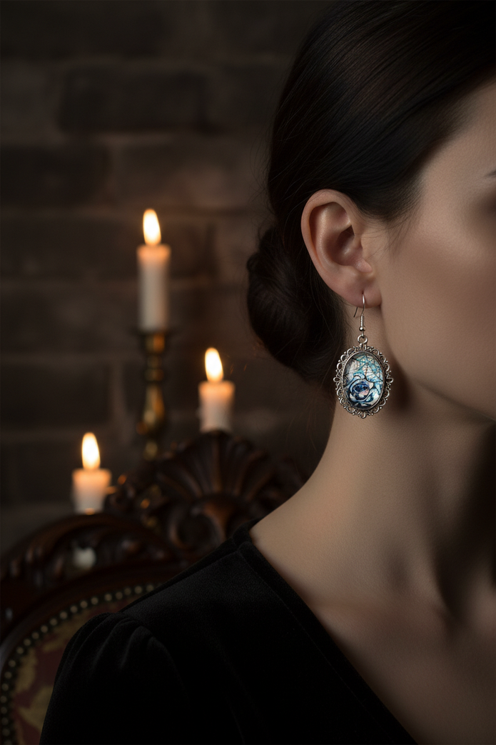 Model wearing iridescent rose spiderweb cabochon drop earrings in moody gothic candlelit setting