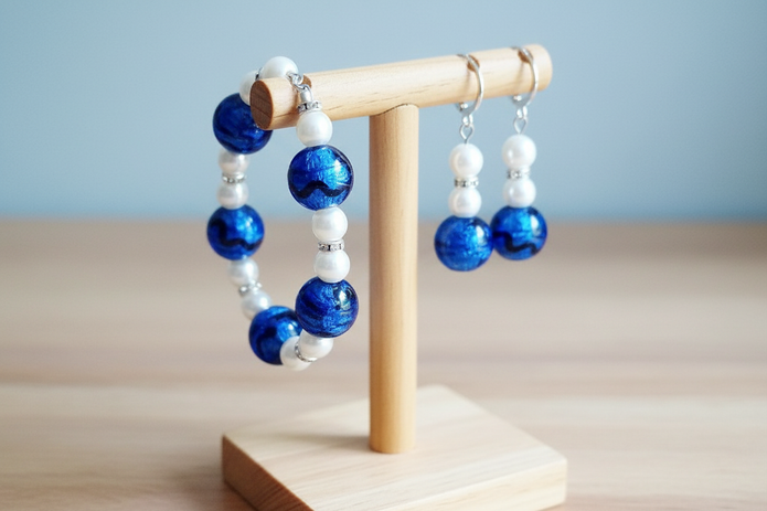 Cobalt blue and pearl jewellery set displayed on wooden jewellery stand with blue background