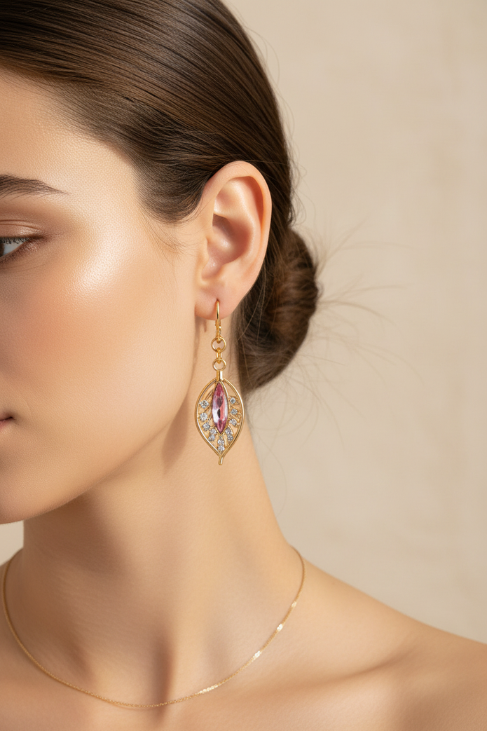 Model wearing gold plated pink crystal filigree leaf drop earrings