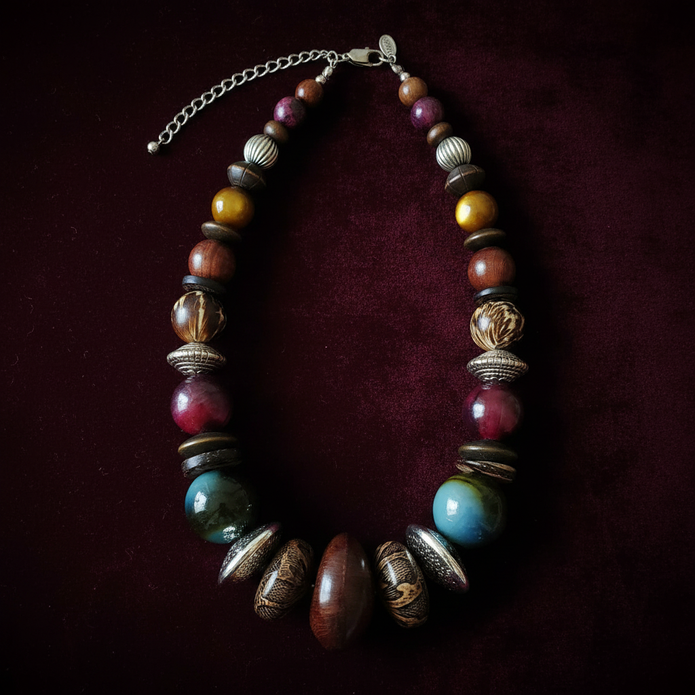 Rescued & Remade jewel tone chunky bead necklace flat lay on dark velvet with moody lighting