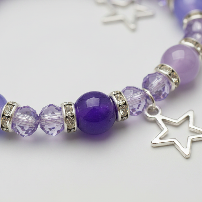Close-up detail of purple beads, crystal spacers and silver rhinestone rondelles on star charm bracelet