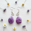 Rescued and remade purple marbled star charm earrings flat lay with dried flowers