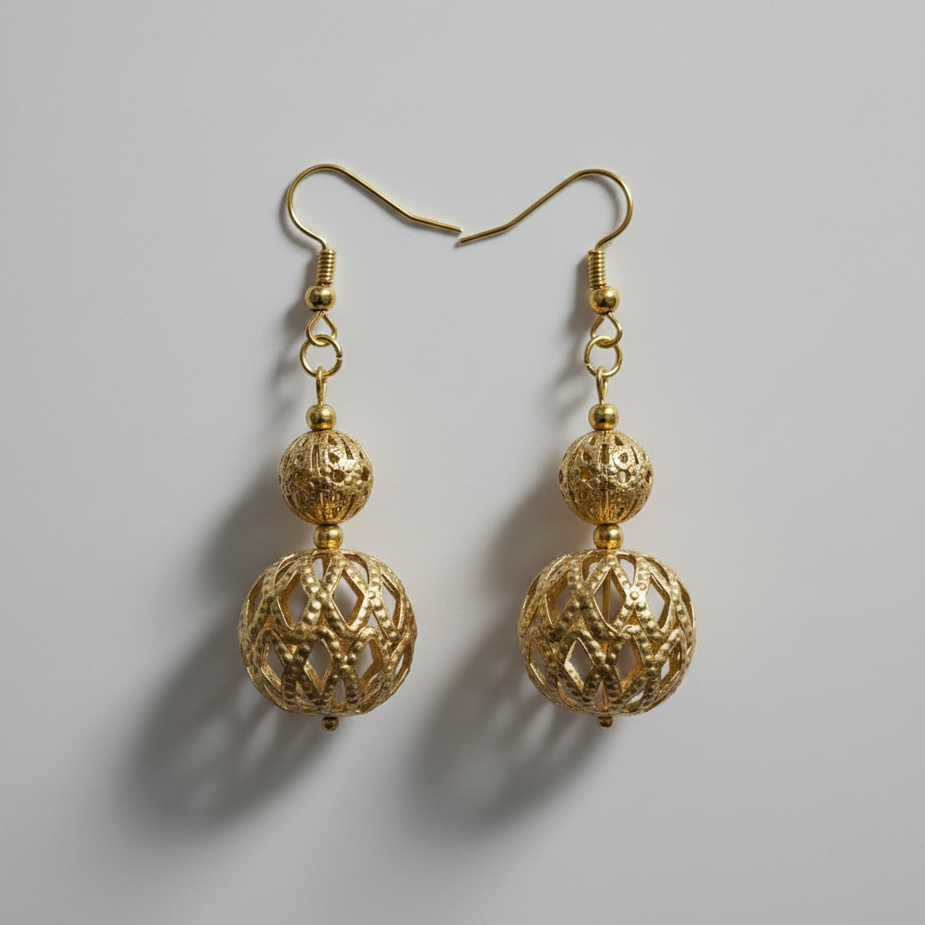 Gold filigree cage bead drop earrings on dark background