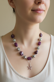 Rescued and remade plum bead necklace with star pendant worn on a model