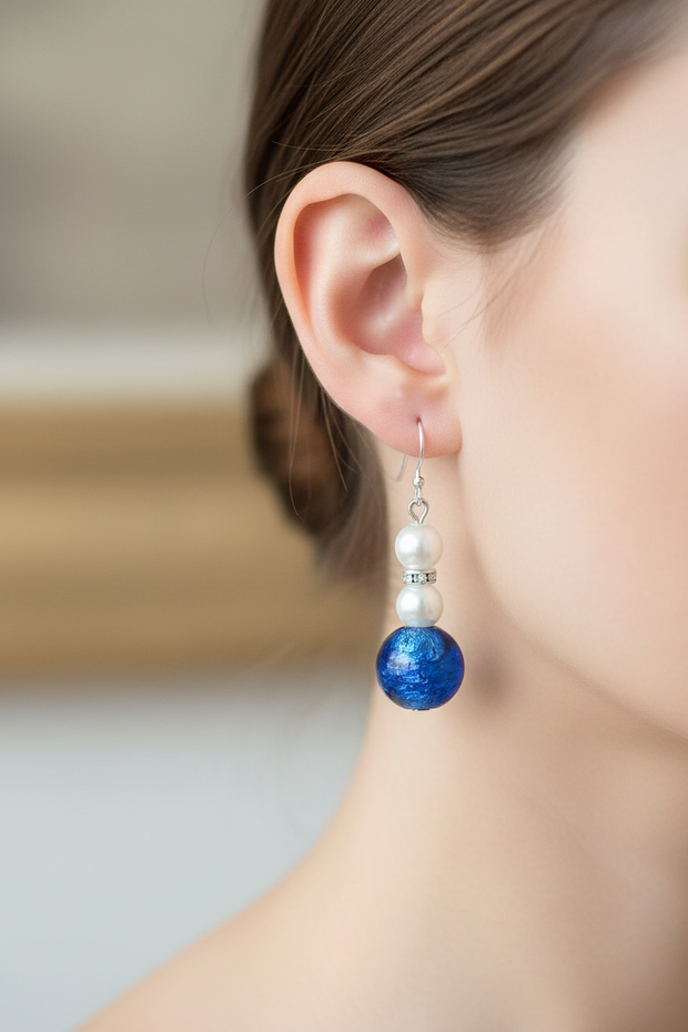 Cobalt blue foil glass and pearl drop earrings worn on model's ear