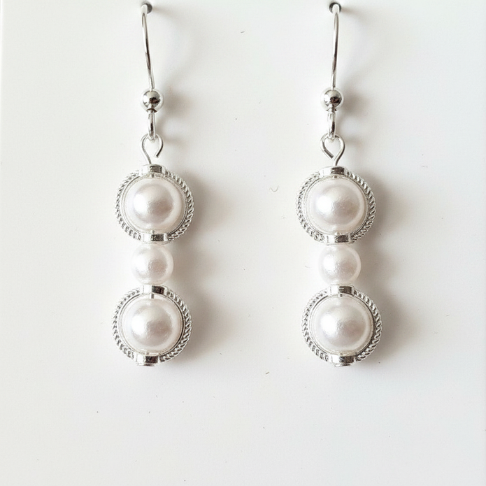 Close-up detail of pearl beads set in silver filigree circle frames