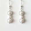 Close-up detail of pearl beads set in silver filigree circle frames