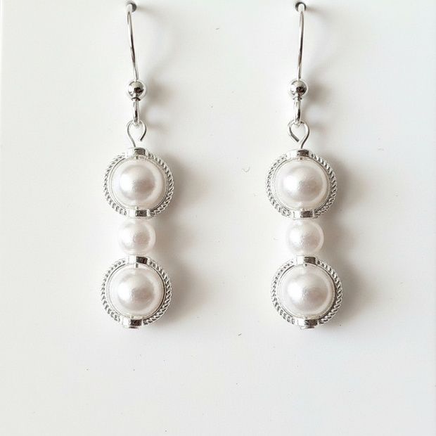 Close-up detail of pearl beads set in silver filigree circle frames