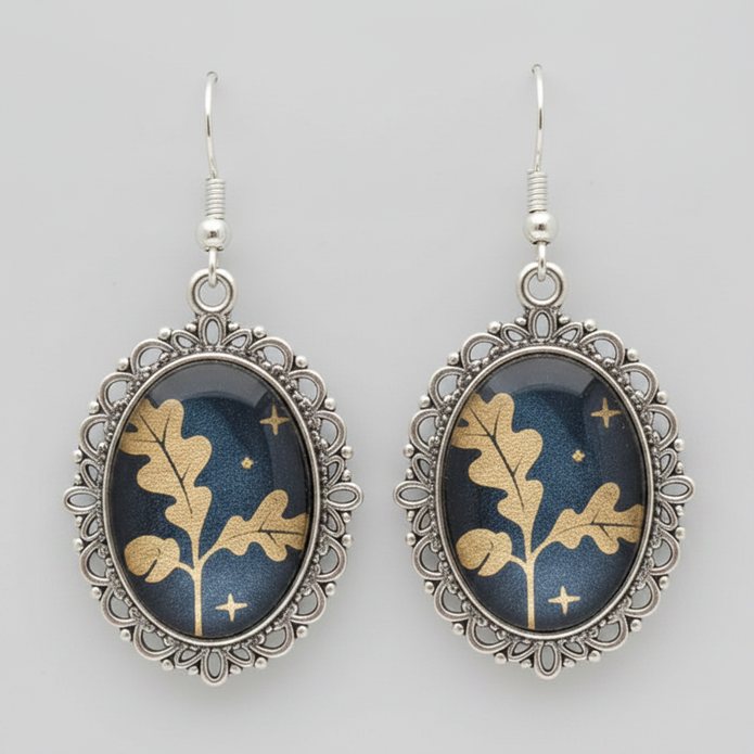 Close-up of antique silver filigree oval earrings with gold oak leaf cabochon detail