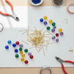 Gold headpins in a craft workspace flat lay with glass beads and jewellery making tools