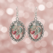 Close-up detail of vintage strawberry cabochon drop earrings showing silver filigree metalwork