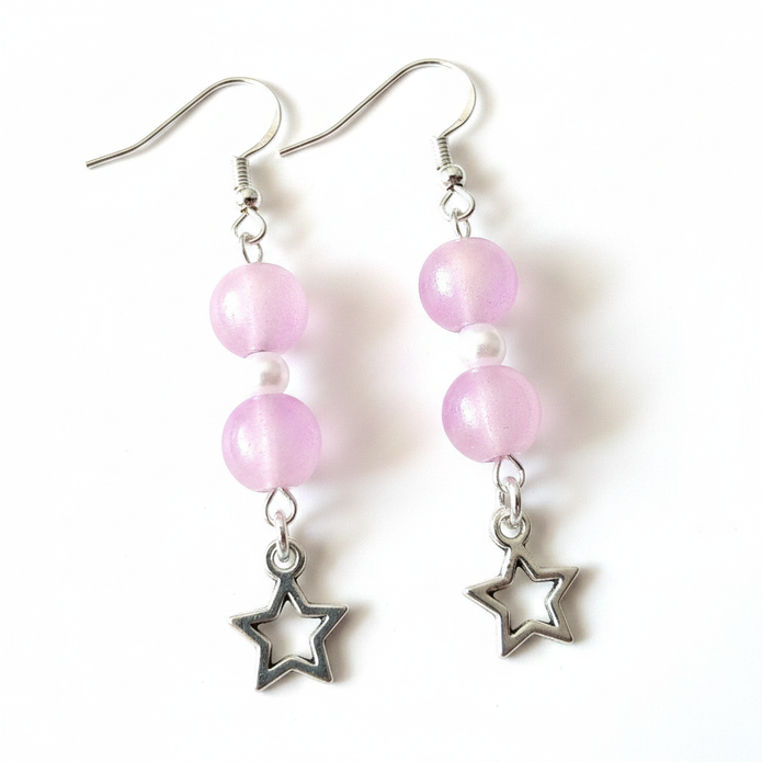 Close-up detail of frosted pink beads and open silver star charm earrings