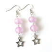 Close-up detail of frosted pink beads and open silver star charm earrings