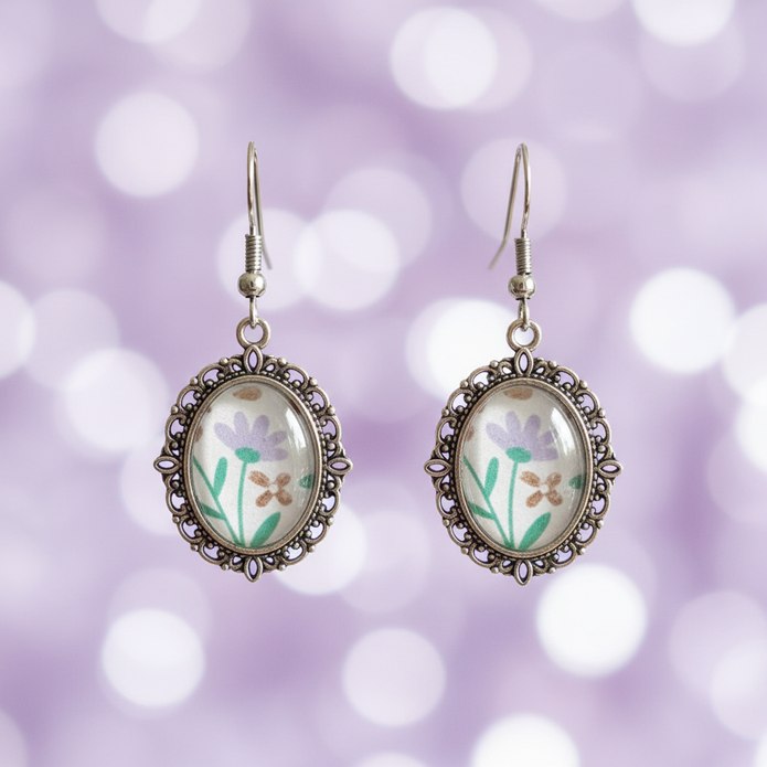 Close-up detail of lavender floral cabochon drop earrings showing silver filigree metalwork