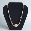 Necklace with beads on a black display stand