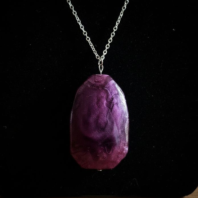 Close up detail of deep purple stone pendant on silver chain