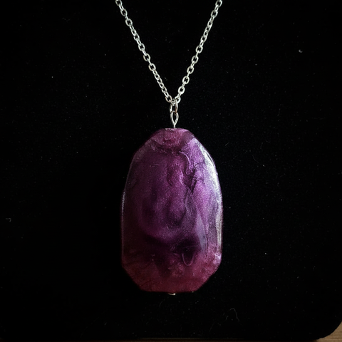 Close up detail of deep purple stone pendant on silver chain